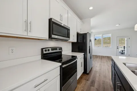 a kitchen with stainless steel appliances a stove microwave and sink