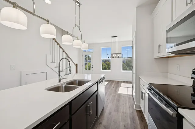 a kitchen with a sink a counter top space stainless steel appliances and cabinets