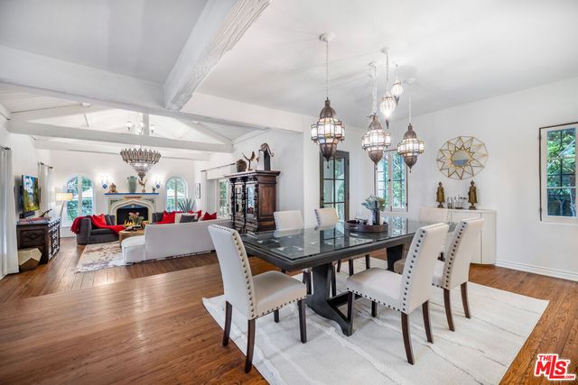 a view of a dining room with furniture a chandelier and wooden floor