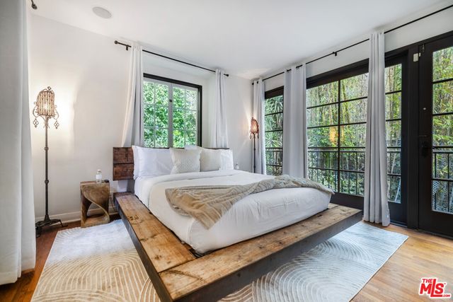 a spacious bedroom with a large bed and a flat tv screen on dresser