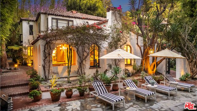 a view of a patio with a table and chairs under an umbrella