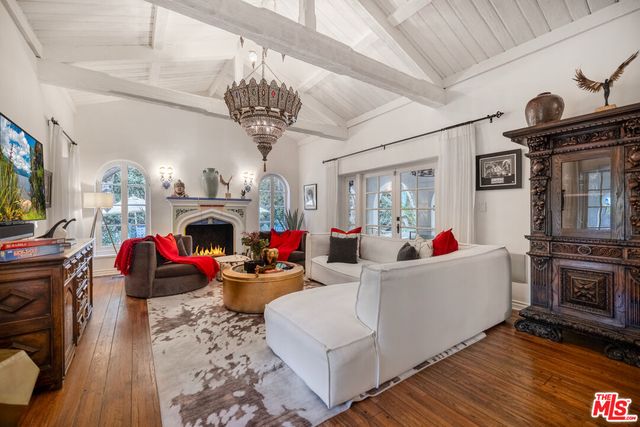 a living room with furniture a fireplace and chandelier