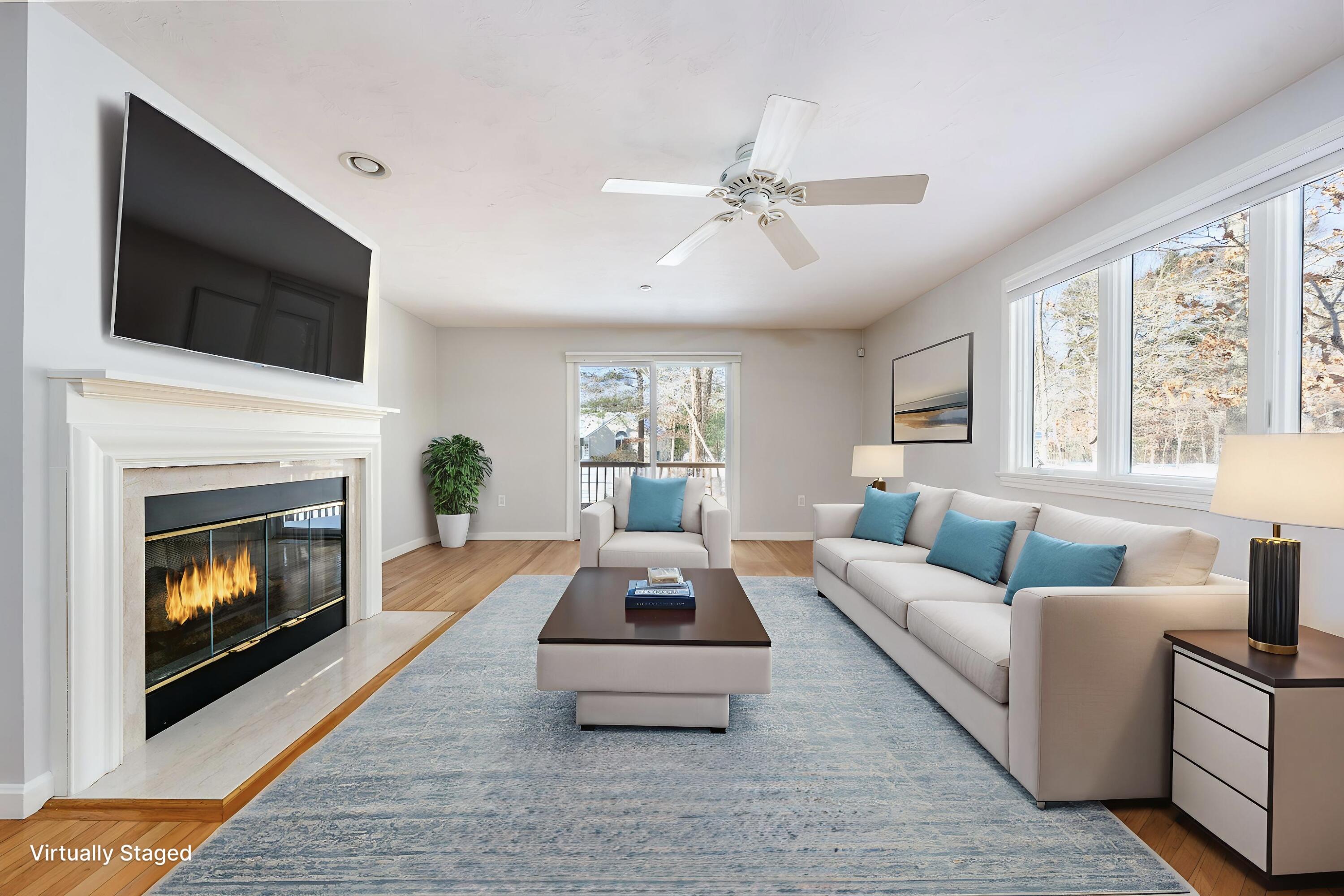a living room with furniture a flat screen tv and a fireplace