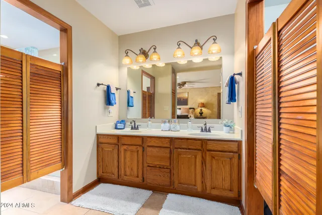 a bathroom with a granite countertop shower a mirror and bathtub