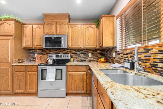 a kitchen with stainless steel appliances granite countertop a stove sink and microwave