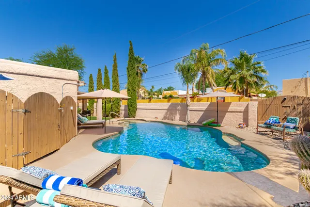 a view of a swimming pool with lounge chairs in the patio