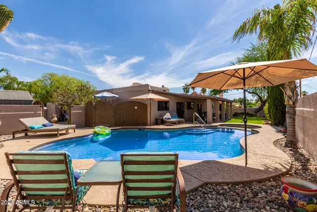 a backyard of a house with table and chairs