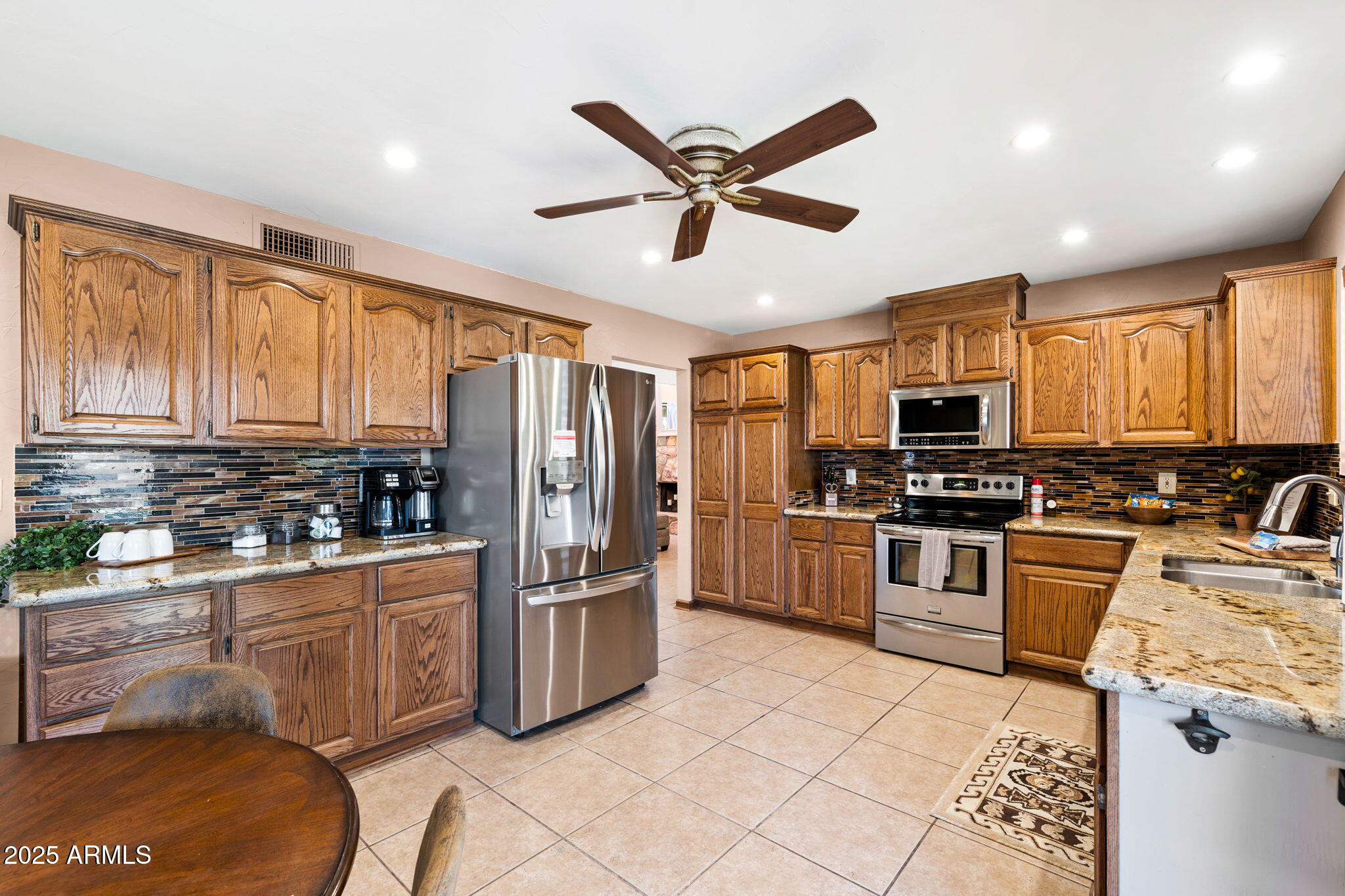 9972 East Del Monte Avenue Gold Canyon, AZ 85118 - Photo 7 of 49 a kitchen with stainless steel appliances granite countertop a refrigerator a stove top oven a sink a dining table and chairs with wooden floor