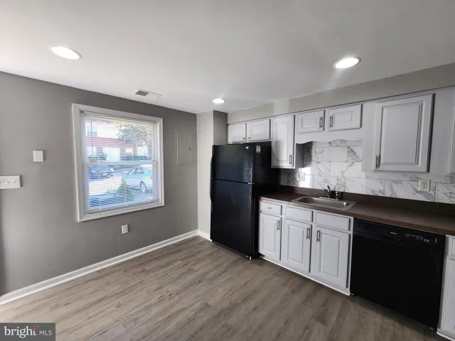 a kitchen with granite countertop a refrigerator stove top oven and sink