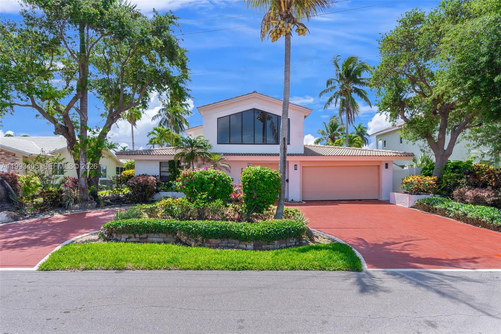 2858 Northeast 33rd Street Lighthouse Point, FL 33064 - Photo 1 of 24 a front view of a house with a yard and potted plants