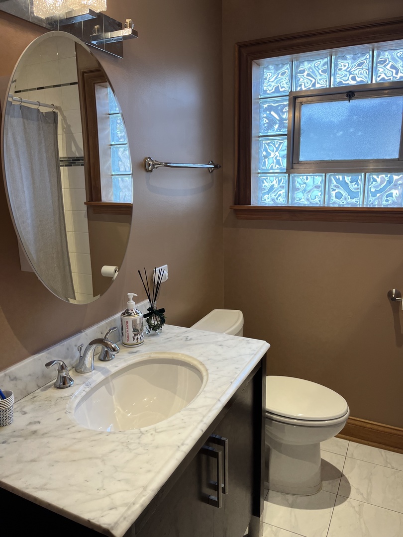 4505 West 55th Street Chicago, IL 60632 - Photo 9 of 15 a bathroom with a granite countertop sink a toilet and mirror