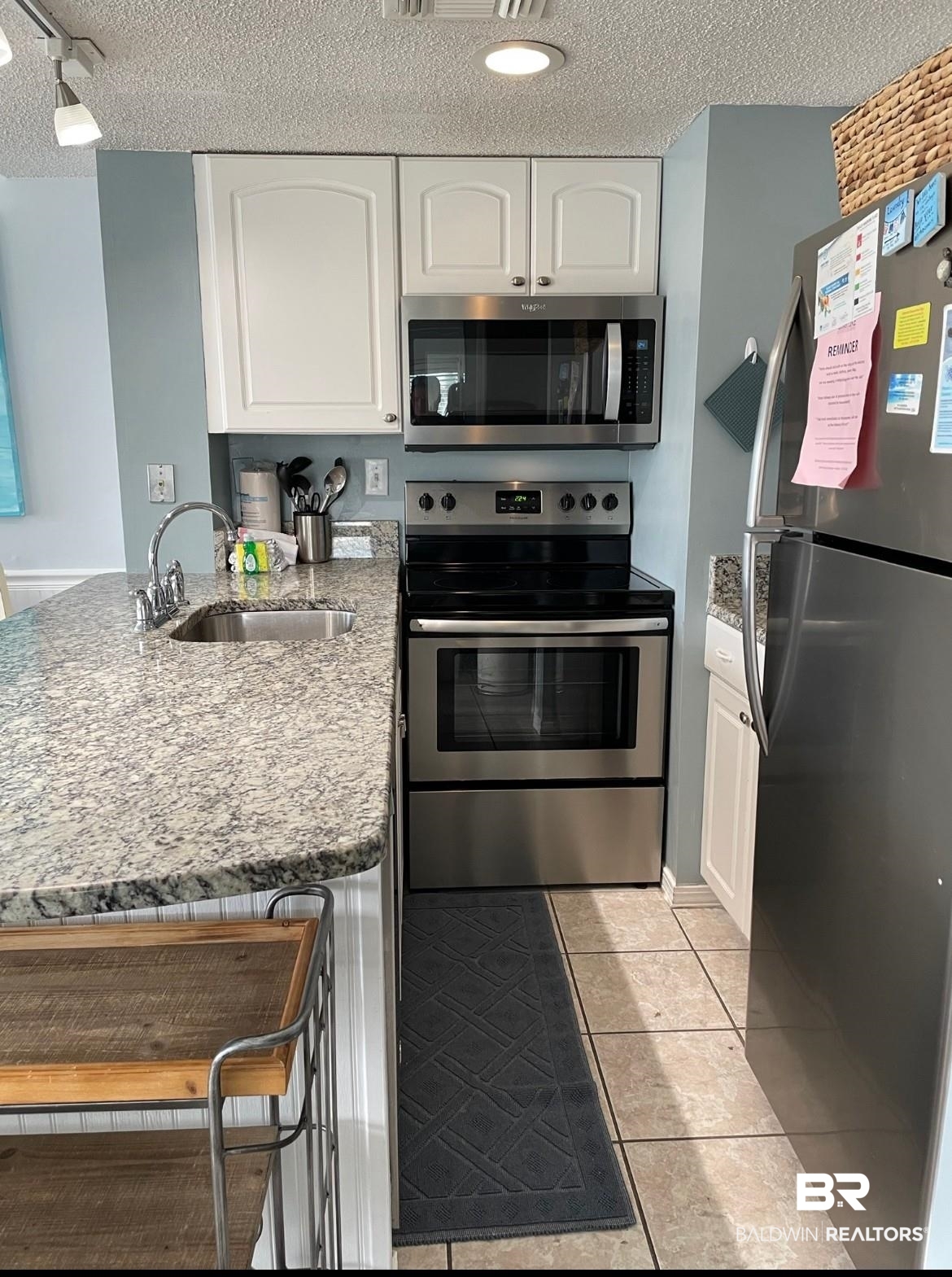 497 Plantation Road, Unit 1156 Gulf Shores, AL 36542 - Photo 5 of 28 Kitchen featuring white cabinetry, a sink, stainless steel appliances, and a peninsula
