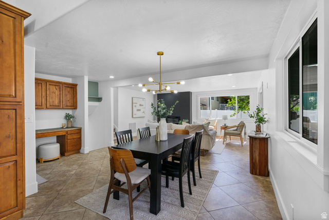 432 Calnette Drive Sandy, UT 84070 - Photo 10 of 48 Dining area featuring tile flooring, a contemporary chandelier, and an integrated desk with wood cabinetry