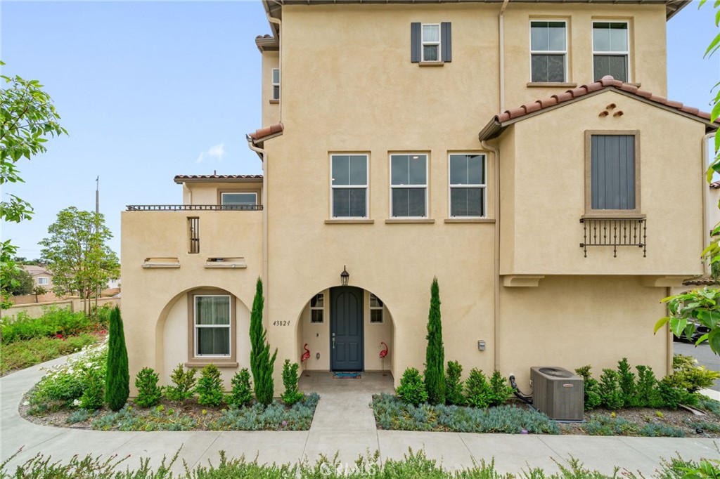 a view of a white house with large windows and a small yard