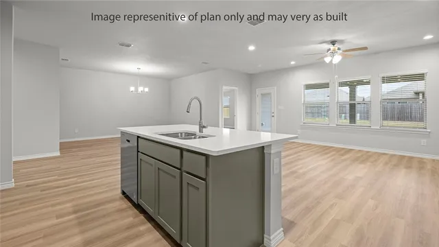 a kitchen with a sink cabinets and wooden floor
