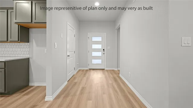 a view of a room with wooden floor and a hallway