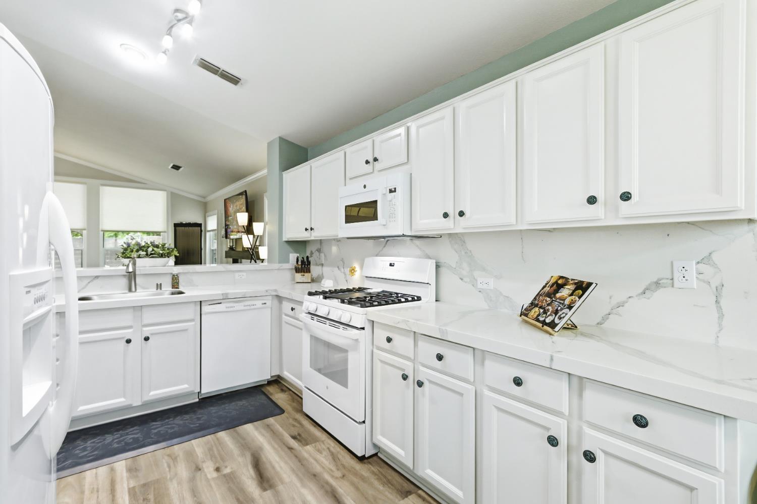 5297 Angelrock Loop Roseville, CA 95747 - Photo 14 of 33 a kitchen with white cabinets appliances and a sink