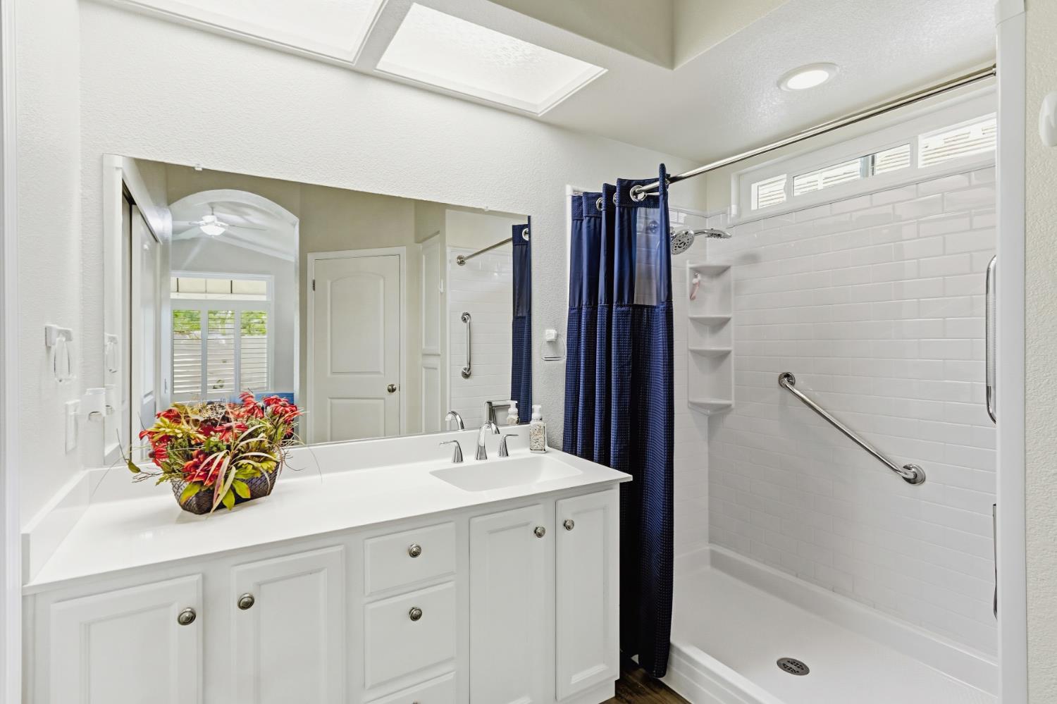 5297 Angelrock Loop Roseville, CA 95747 - Photo 22 of 33 a bathroom with a sink mirror and a shower