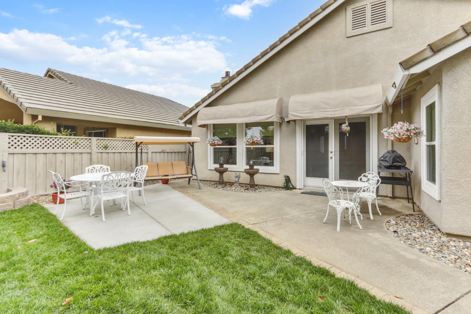 5297 Angelrock Loop Roseville, CA 95747 - Photo 31 of 33 a view of a patio with table and chairs and potted plants with wooden fence