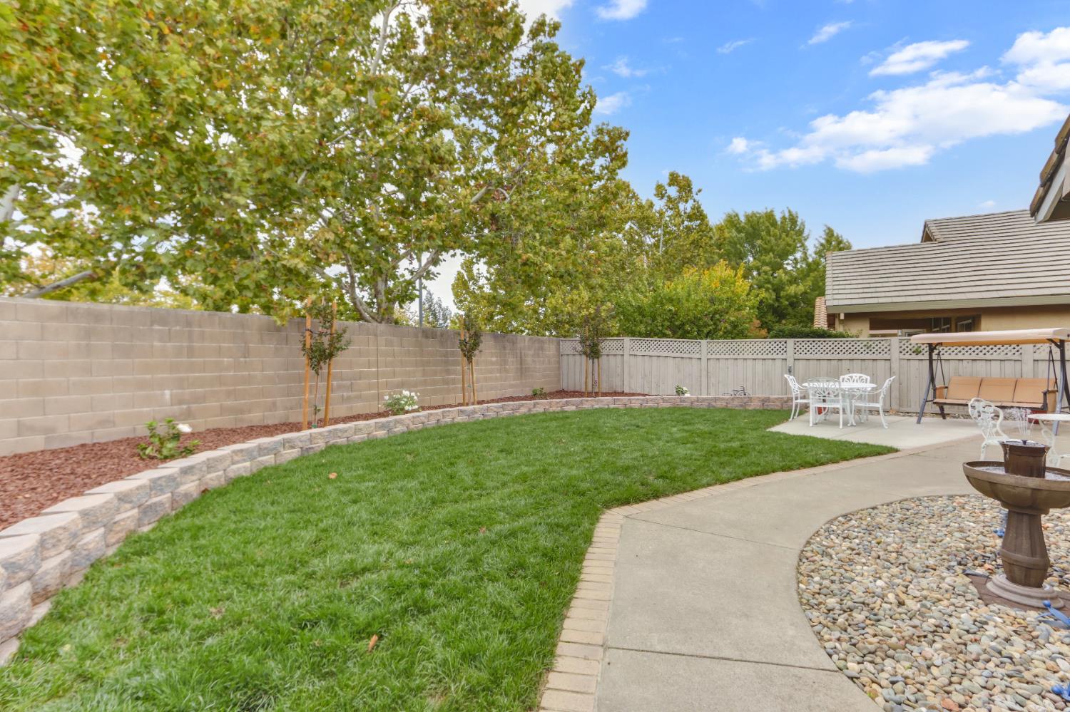 5297 Angelrock Loop Roseville, CA 95747 - Photo 32 of 33 a view of a backyard with table and chairs and wooden fence