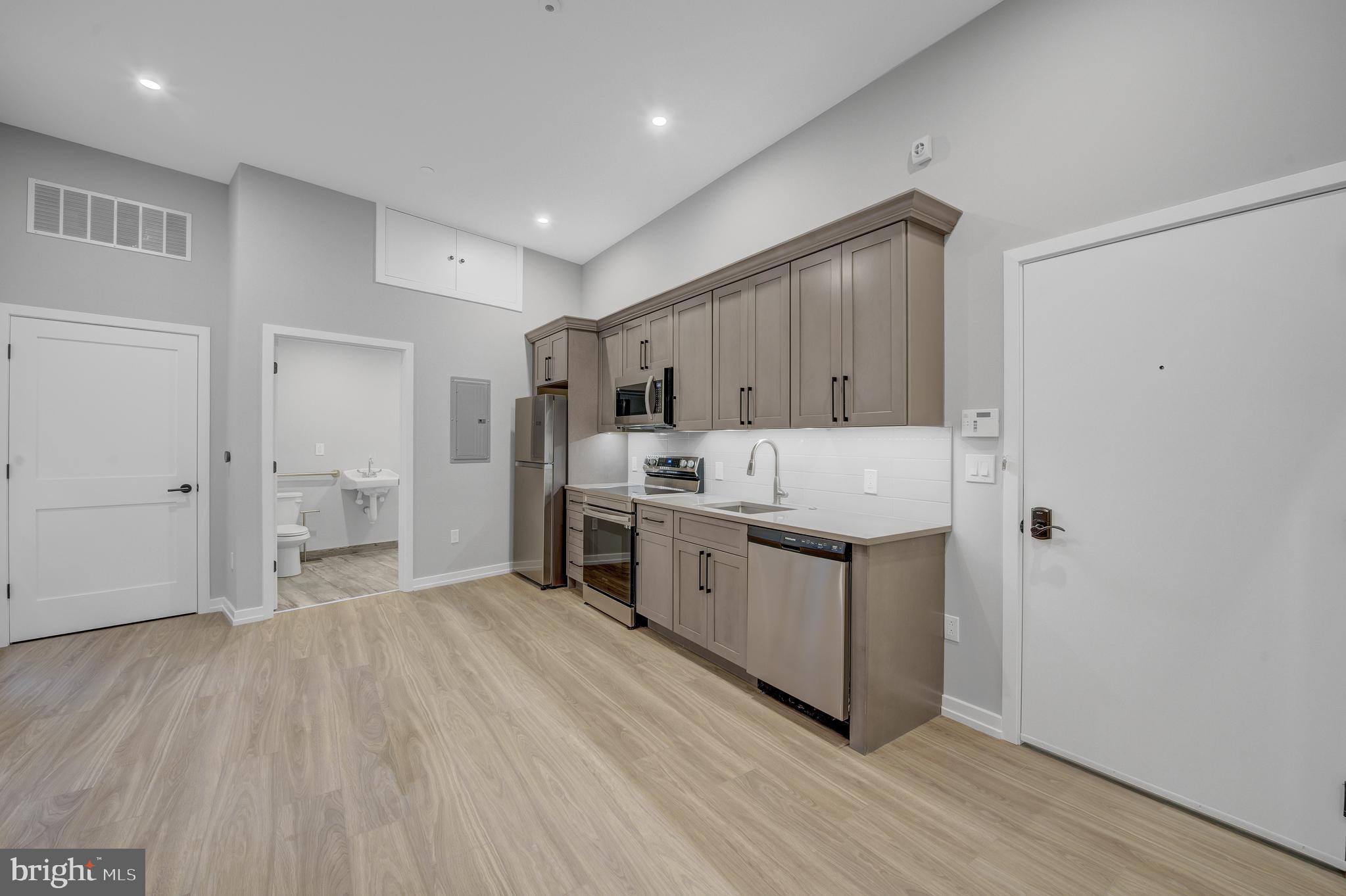 a large kitchen with a lot of counter space and wooden floor