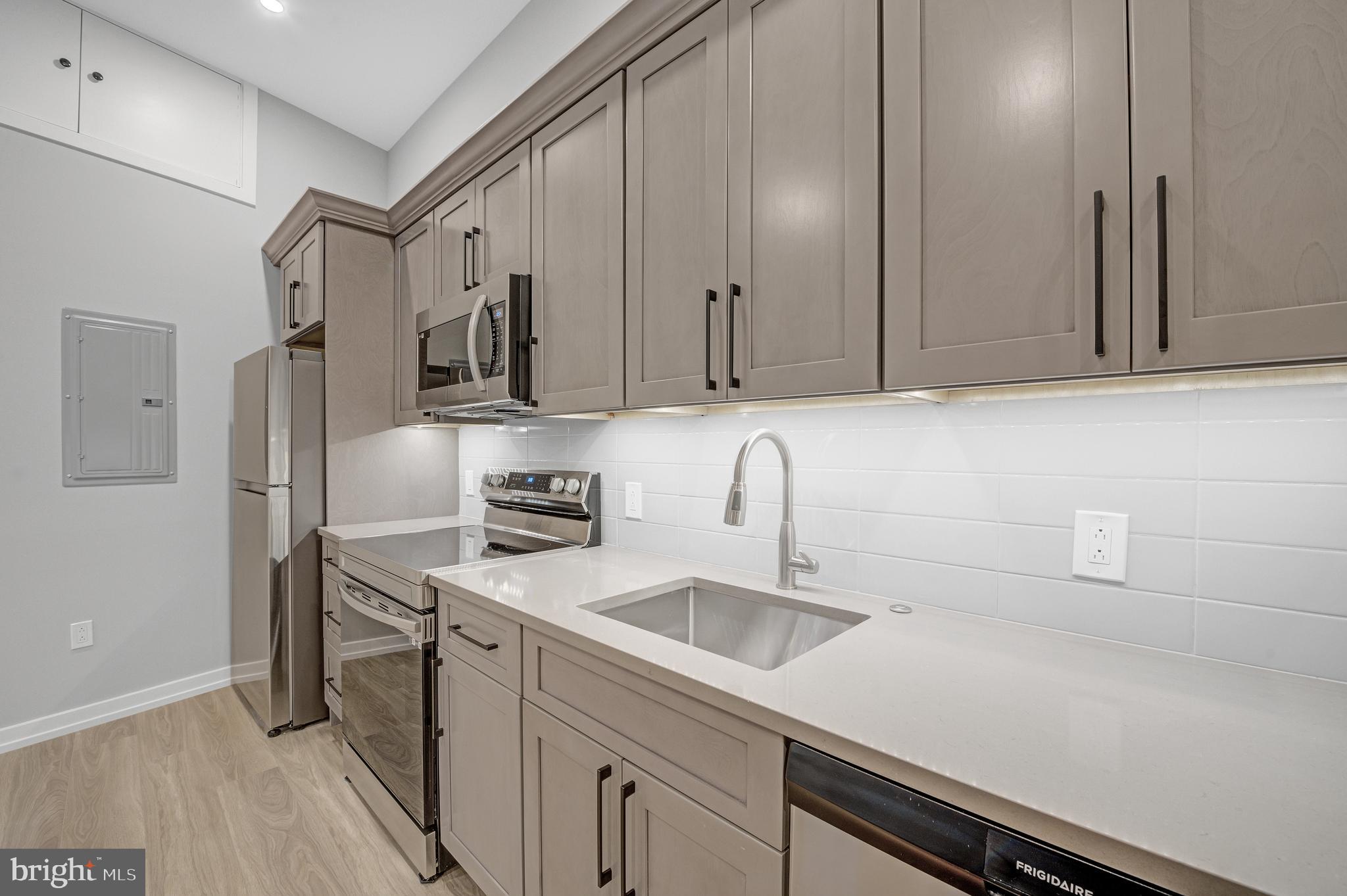 2445 Innovator Way, Unit 1A Philadelphia, PA 19146 - Photo 13 of 14 a kitchen with stainless steel appliances a sink dishwasher refrigerator stove and cabinets
