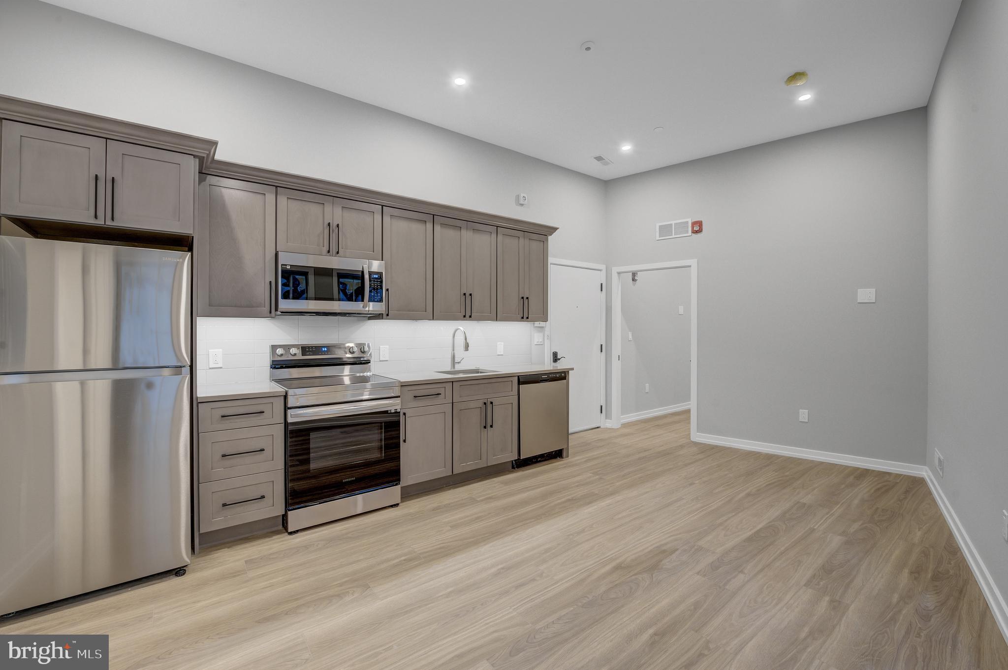 2445 Innovator Way, Unit 1A Philadelphia, PA 19146 - Photo 5 of 14 a large kitchen with a refrigerator a stove top oven a sink and dishwasher