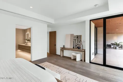 a view of a hallway with bathroom and mirror
