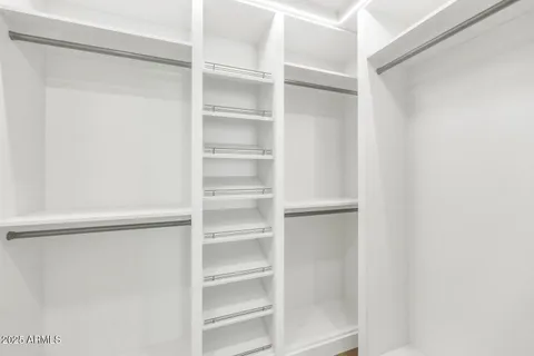 a view of walk in closet with empty racks