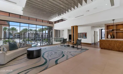 a living room with furniture large windows and wooden floor