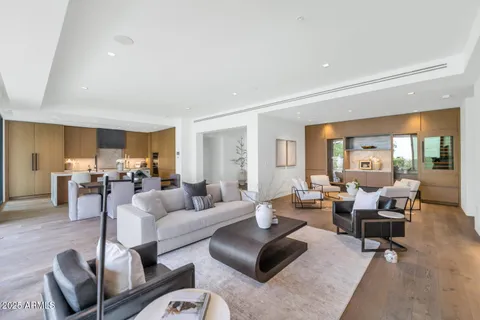 a living room with furniture wooden floor and a large window