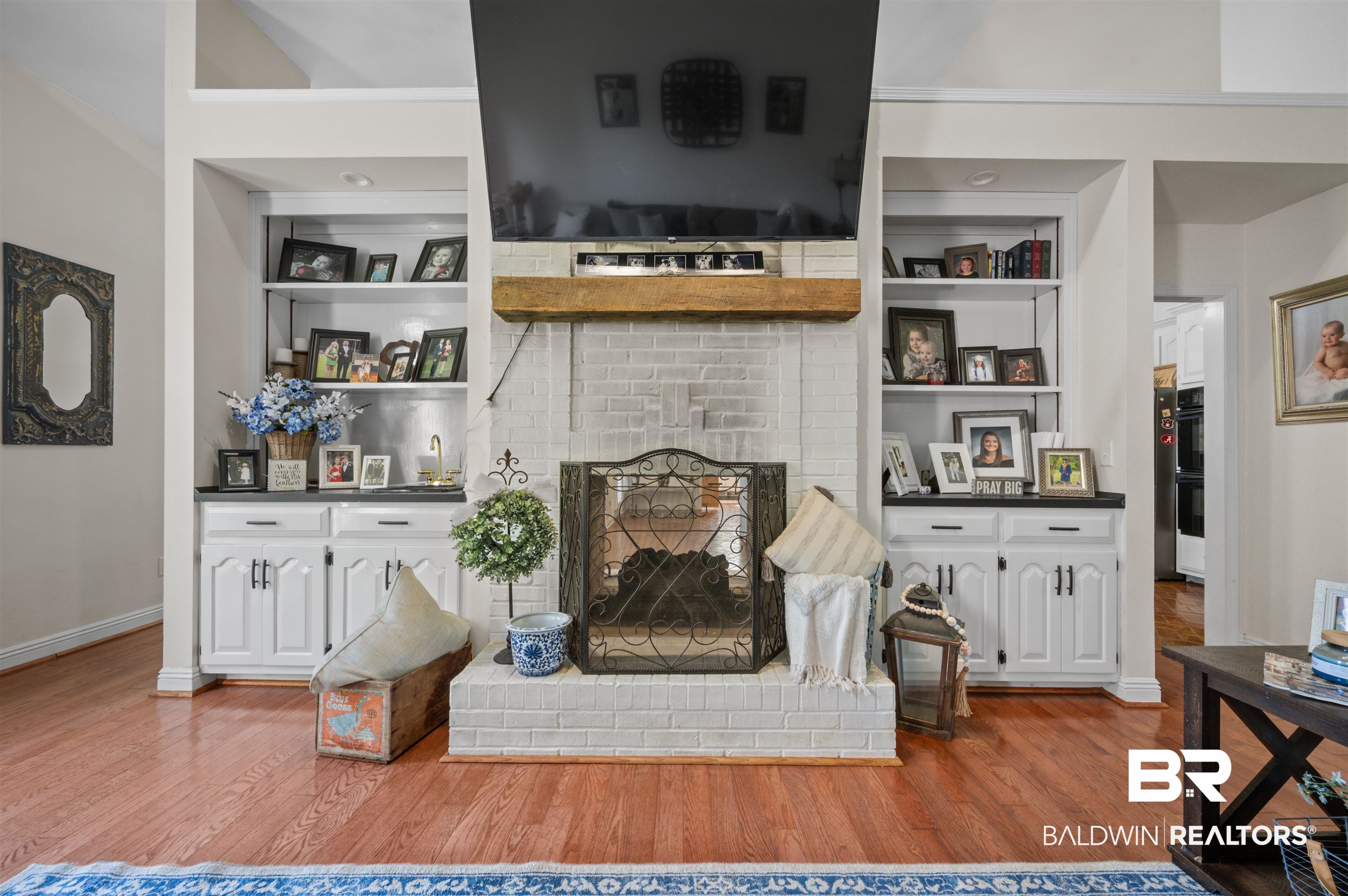 141 Blue Ridge Drive Monroeville, AL 36460 - Photo 9 of 40 Living area featuring wood finished floors, built in shelves, and a brick fireplace