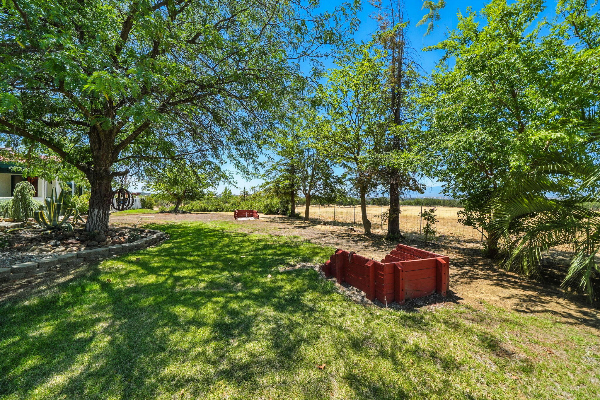 10750 Dixie Road Red Bluff, CA 96080 - Photo 45 of 75 a backyard of a house with table and chairs under a large tree