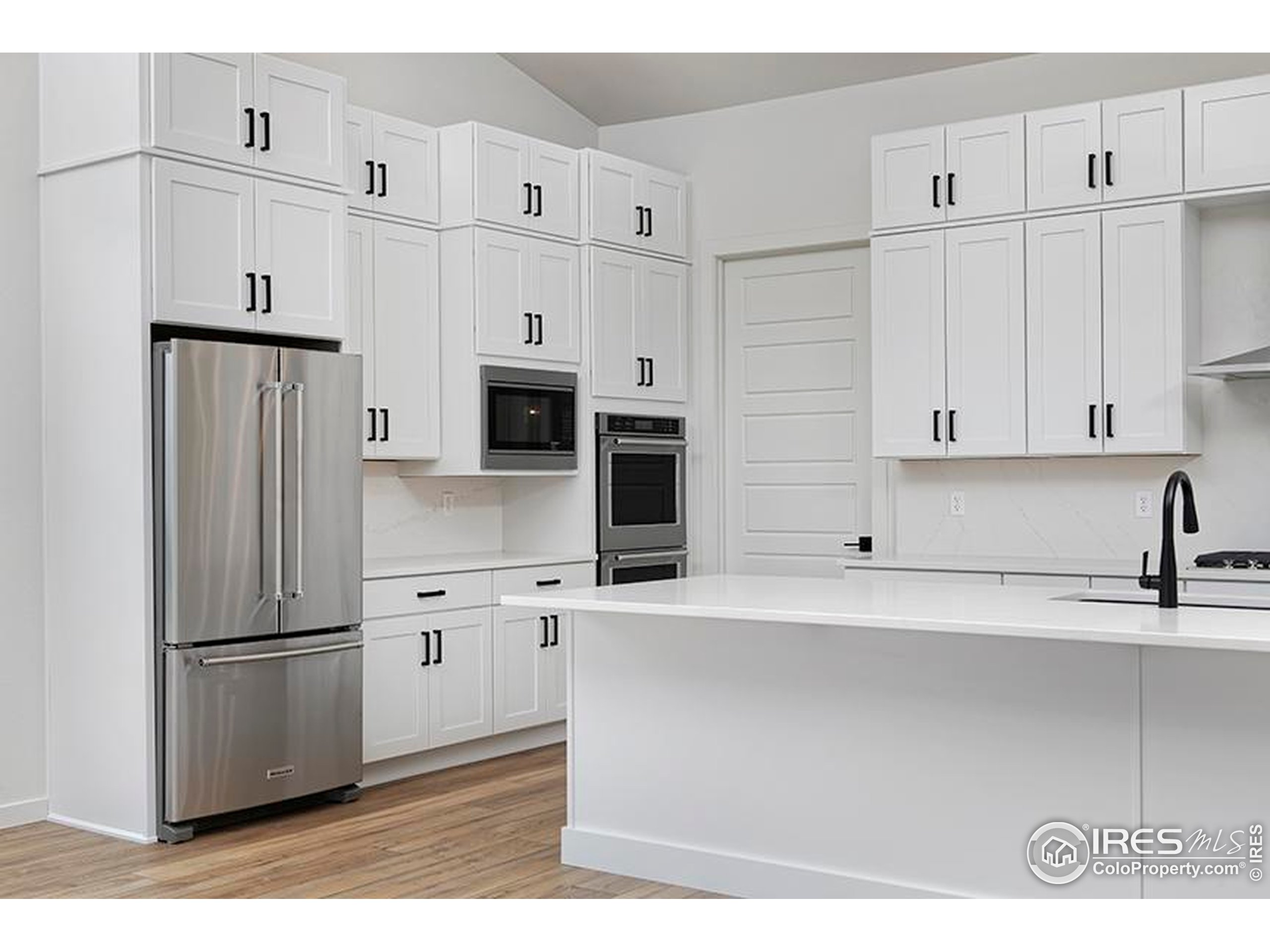 1738 Morningstar Way Fort Collins, CO 80524 - Photo 13 of 49 a kitchen with stainless steel appliances a refrigerator stove and white cabinets