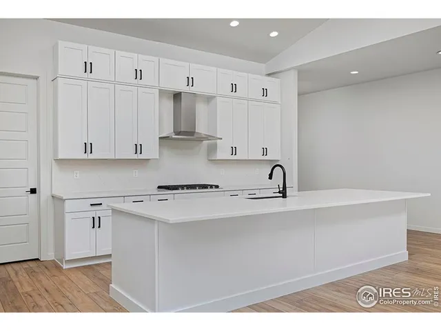 a kitchen with stainless steel appliances granite countertop a sink white cabinets and a granite counter tops