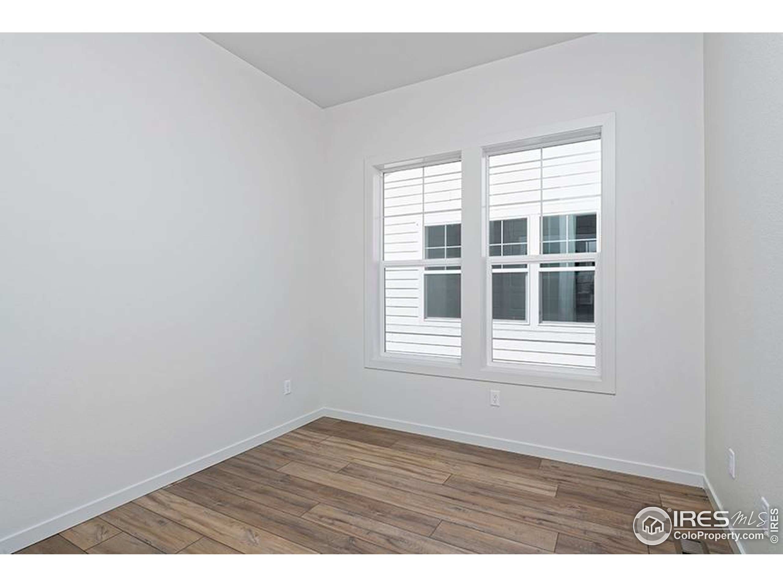 1738 Morningstar Way Fort Collins, CO 80524 - Photo 24 of 49 a view of an empty room with wooden floor and window