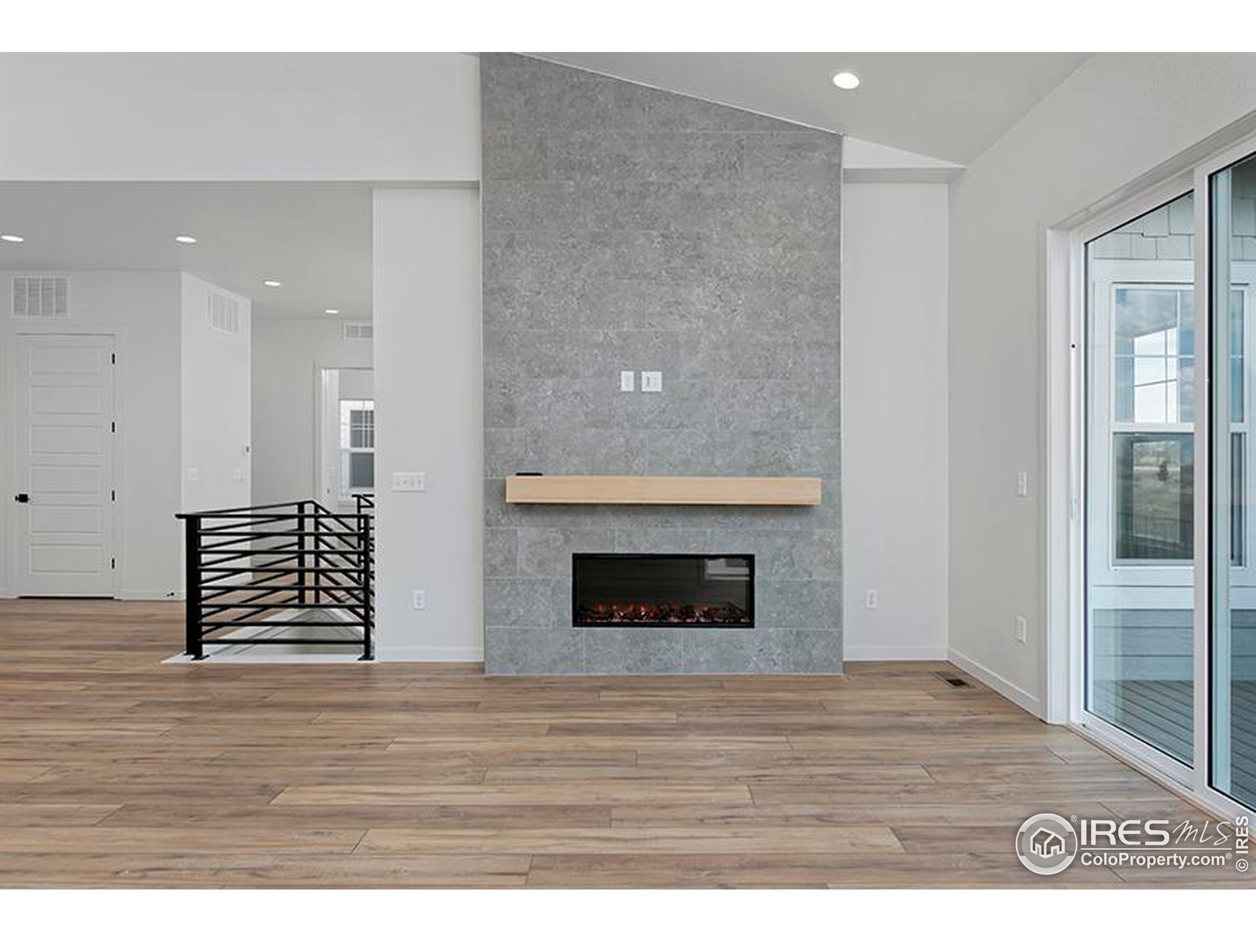 1738 Morningstar Way Fort Collins, CO 80524 - Photo 7 of 49 a view of an empty room with wooden floor and a fireplace