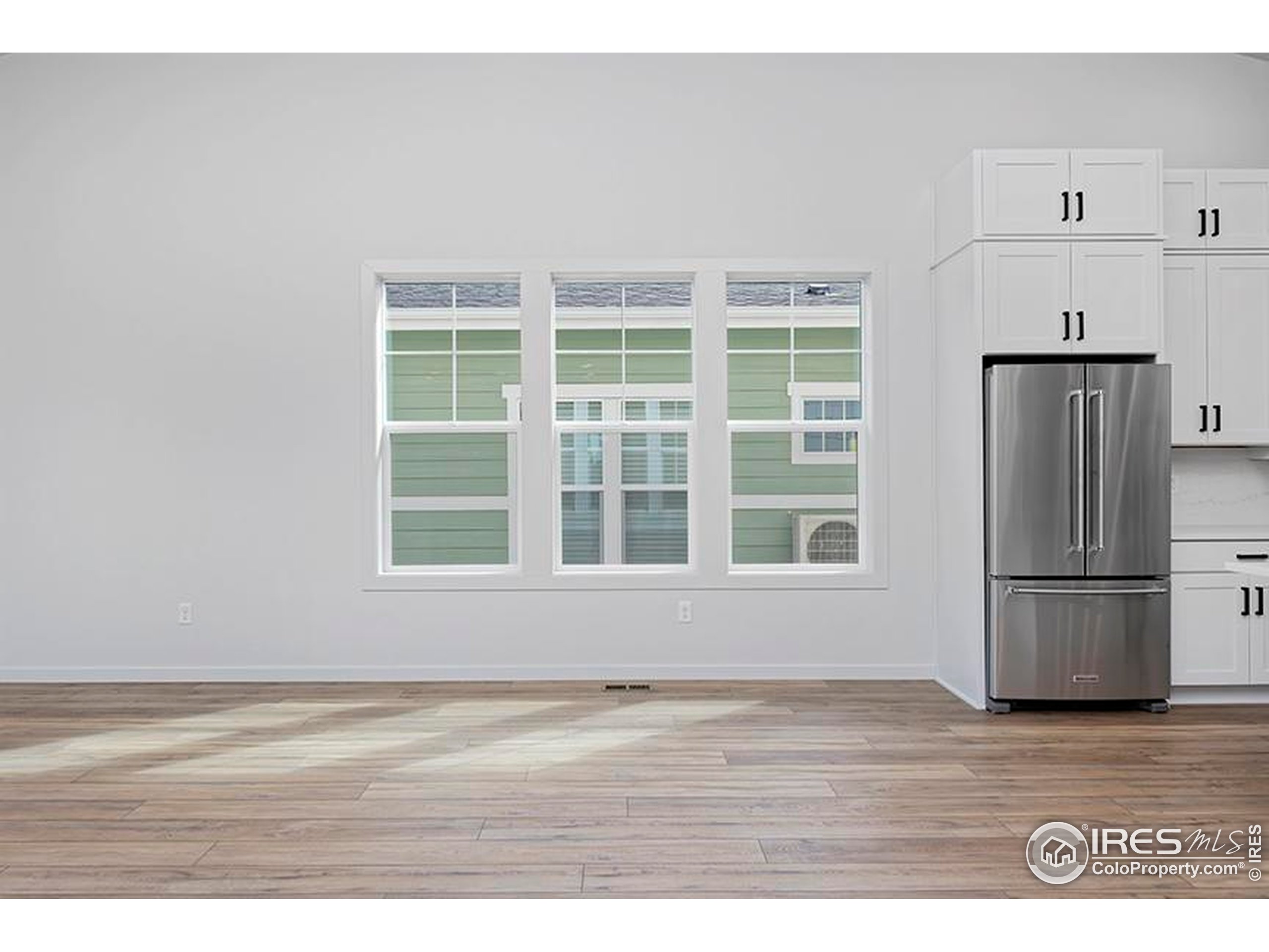 1738 Morningstar Way Fort Collins, CO 80524 - Photo 8 of 49 a view of an empty room with wooden floor and a window