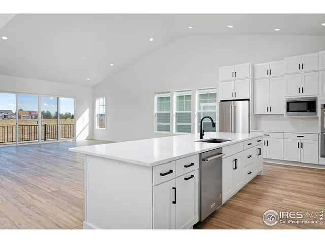 a kitchen with white cabinets appliances and a center island