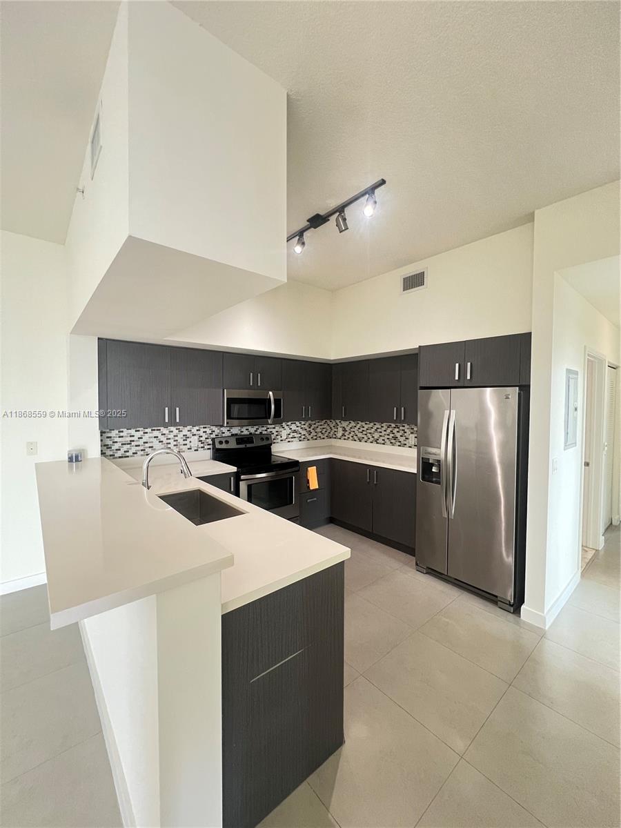 729 Northwest 2nd Street, Unit 1225 Miami, FL 33128 - Photo 1 of 18 a kitchen with stainless steel appliances a refrigerator and a stove