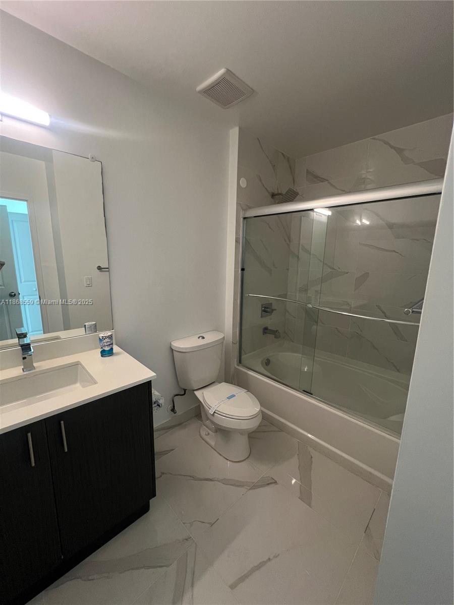 729 Northwest 2nd Street, Unit 1225 Miami, FL 33128 - Photo 11 of 18 a bathroom with a sink a toilet and shower