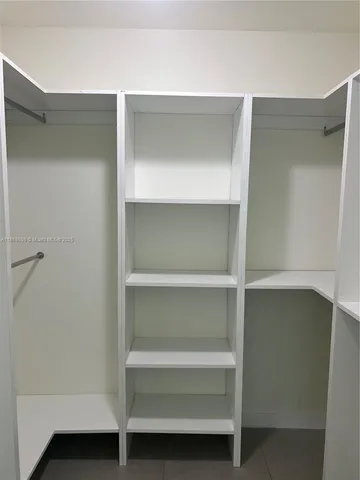 an empty room with closet and windows