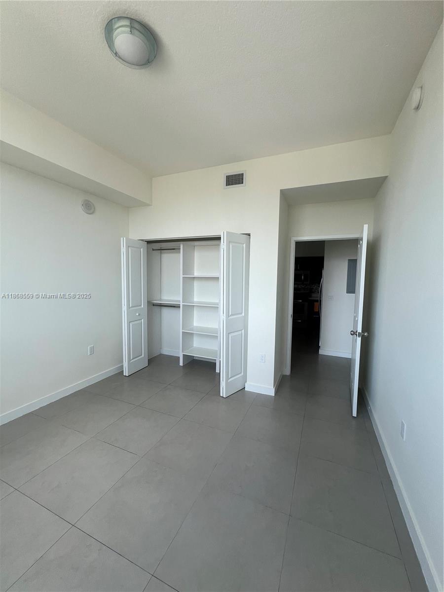 729 Northwest 2nd Street, Unit 1225 Miami, FL 33128 - Photo 14 of 18 an empty room with closet and windows