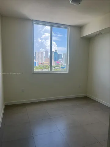 a view of an empty room with cabinet and entryway