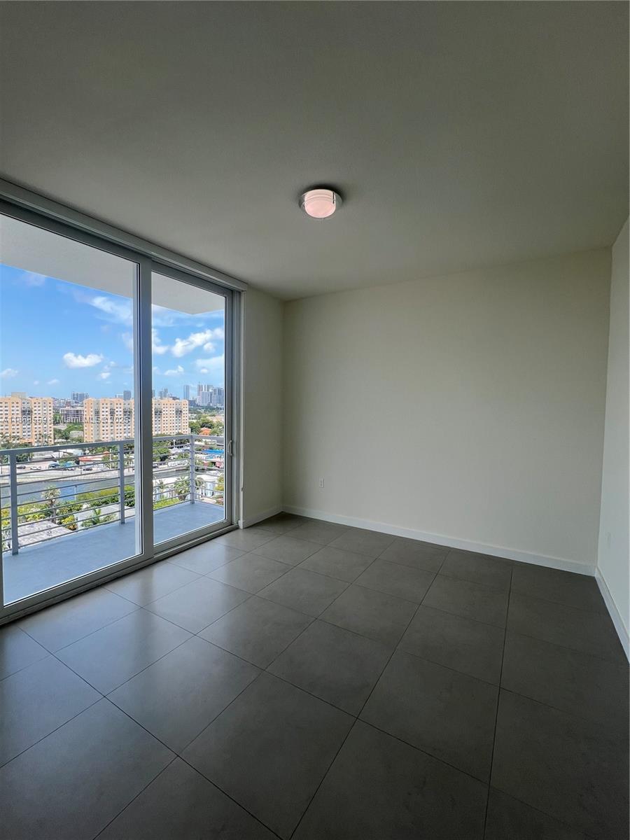729 Northwest 2nd Street, Unit 1225 Miami, FL 33128 - Photo 16 of 18 wooden floor in an empty room with glass door