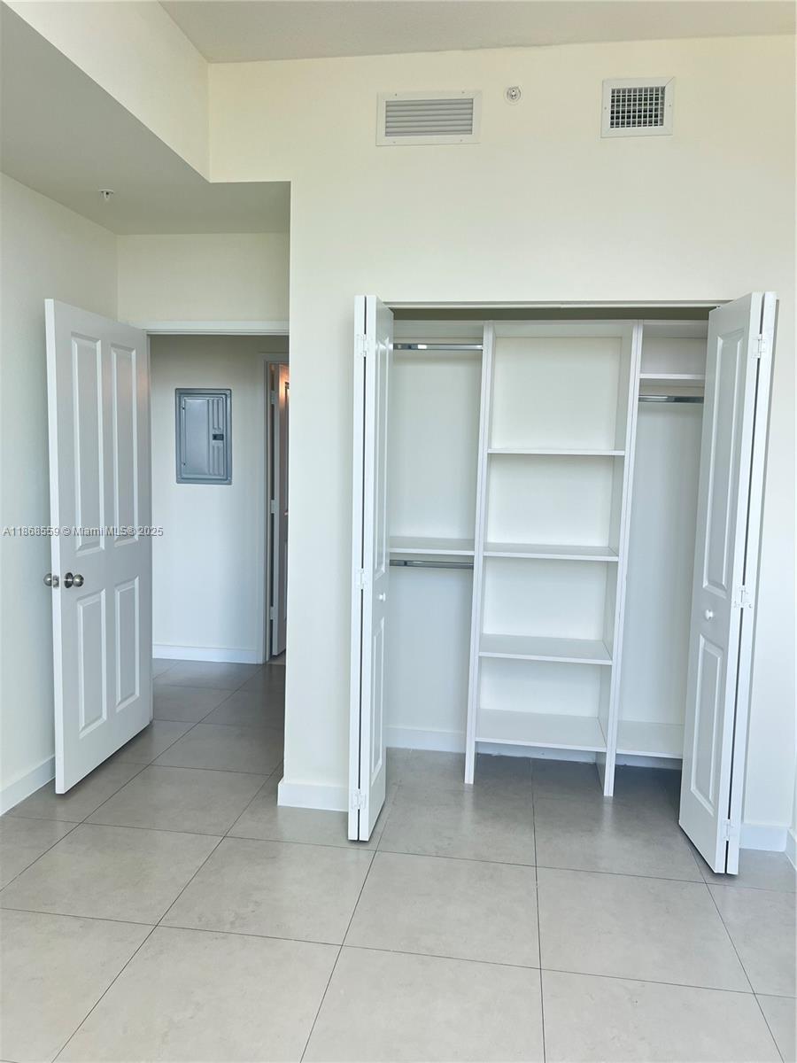 729 Northwest 2nd Street, Unit 1225 Miami, FL 33128 - Photo 17 of 18 a view of an empty room with cabinet and entryway