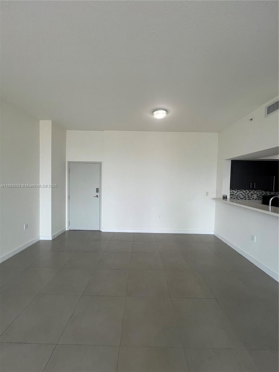 729 Northwest 2nd Street, Unit 1225 Miami, FL 33128 - Photo 2 of 18 a view of an empty room and a kitchen
