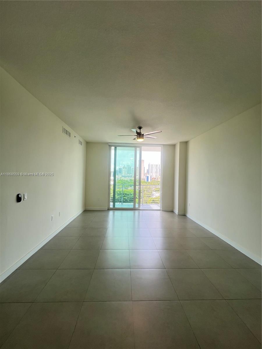 729 Northwest 2nd Street, Unit 1225 Miami, FL 33128 - Photo 5 of 18 a view of an empty room with a fireplace and a window