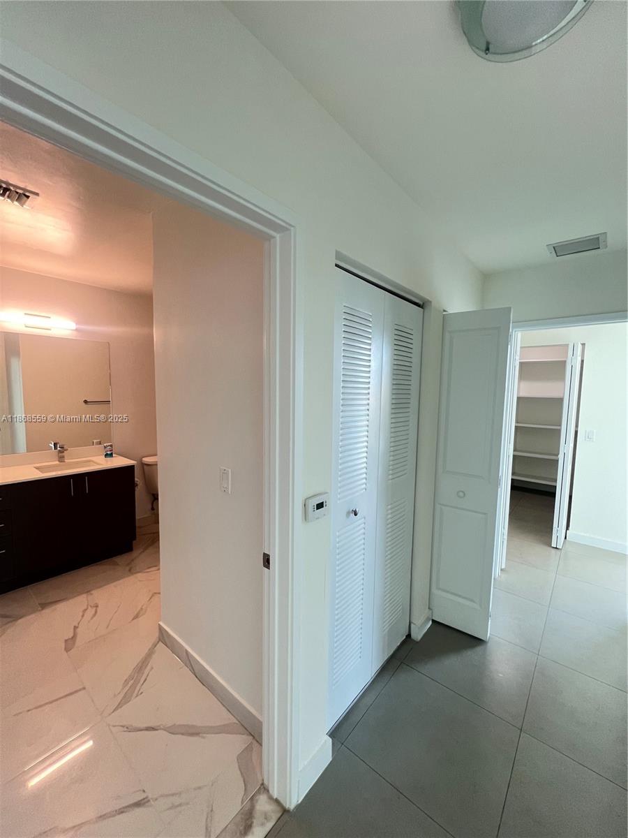 729 Northwest 2nd Street, Unit 1225 Miami, FL 33128 - Photo 10 of 18 a view of a walk in closet and bedroom