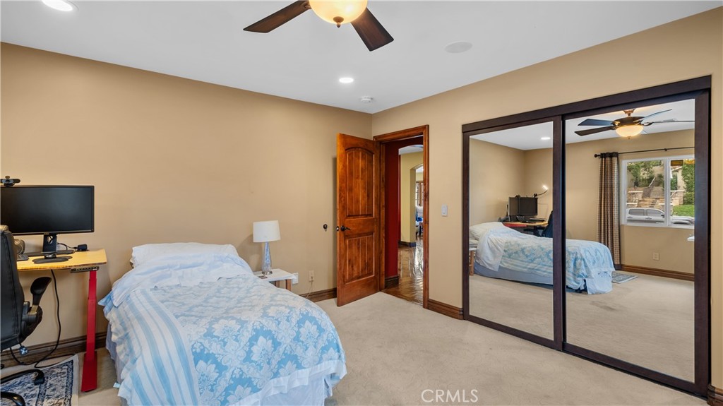 24604 Apple Street Newhall, CA 91321 - Photo 30 of 47 a bedroom with a bed and a flat tv screen on the dresser